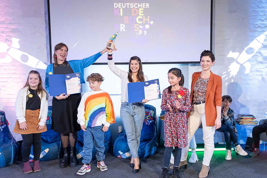 Josephine Wolff, Annika Preil und Moderatorin Daniela Loeff mit Mitglieder der Kinderjury | © Deutscher Kinderbuchpreis